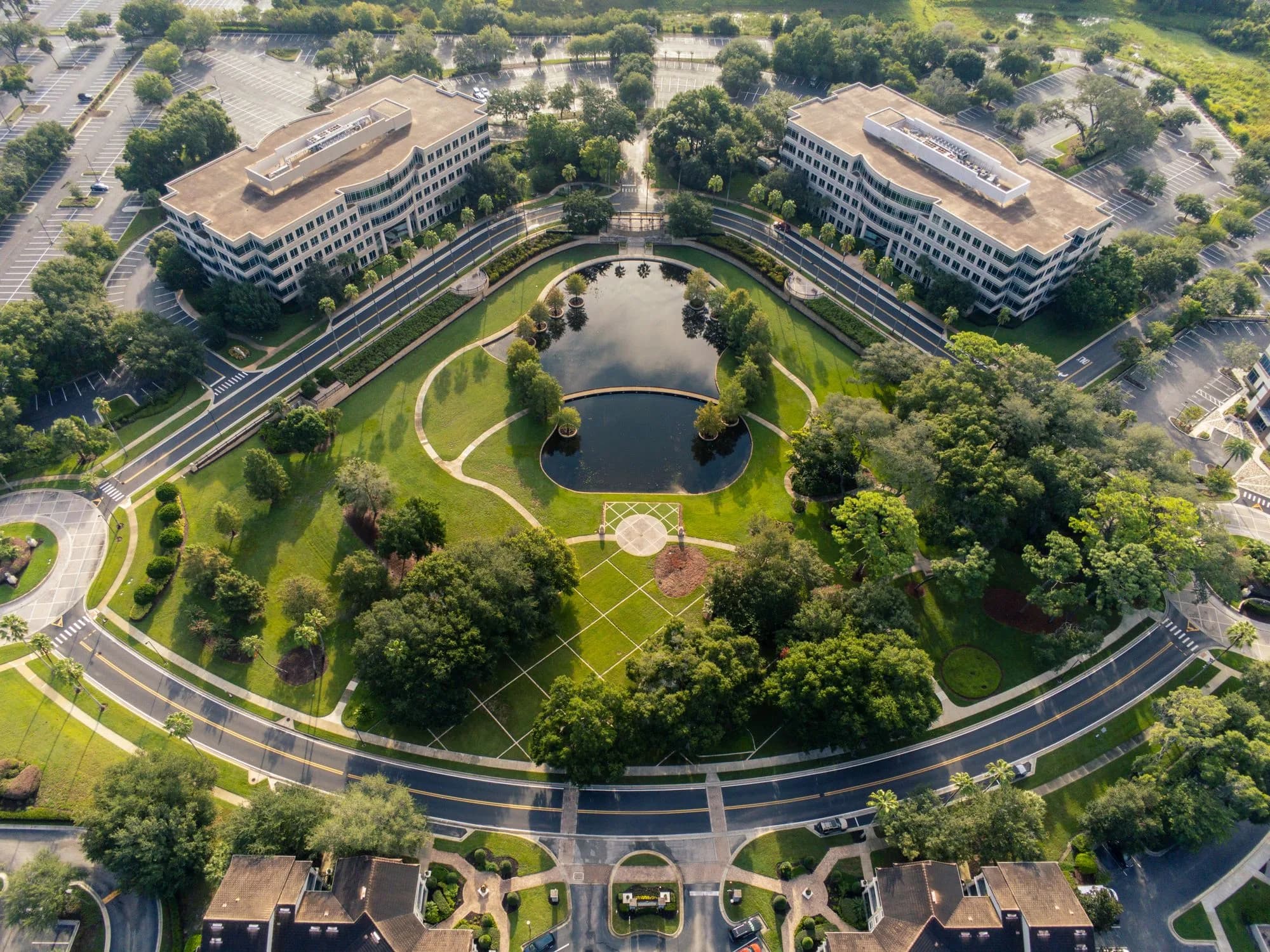 Vista aérea de un campus de oficinas con dos edificios de mediana altura y un estanque